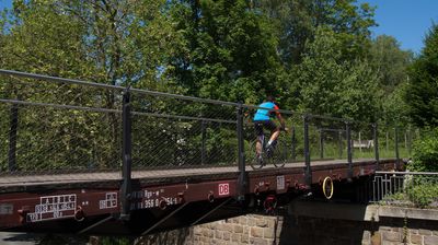 Diese Radlerbrücke besteht aus einem alten Eisenbahnwaggon.